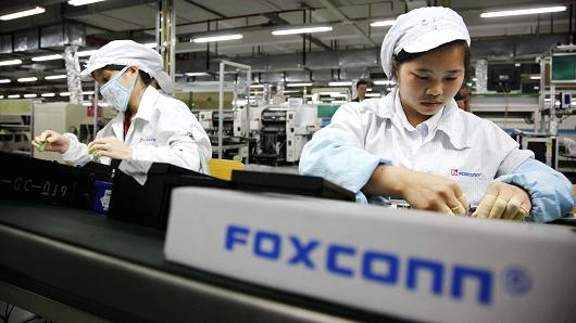 Foxconn employees on the assembly line in Longhua, Shenzhen, China. The company reportedly employed students working overtime at its iPhone factory in Zhengzhou.