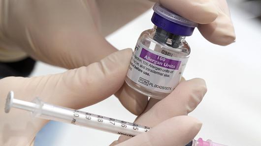 A clinical technician holds a syringe and a vial of Allergan Botox, produced by Allergan.