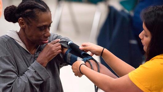 A nurse checks the blood pressure of a patient at Greensville County High School, in Emporia, Virginia.