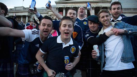 Scotland fans in joyous mood drinking and singing together in Trafalgar Square ahead of their football match, England vs Scotland, World Cup Qualifiers Group stage on 11th November 2016
