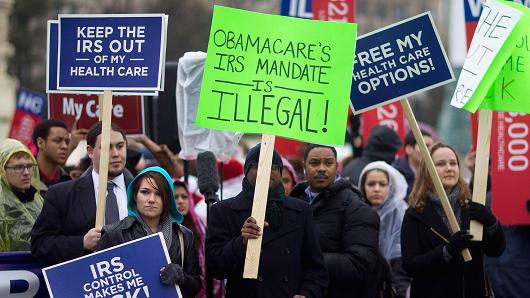 Demonstrators opposed to U.S. President Barack Obama's health-care law, Obamacare, hold signs in front of the U.S. Supreme Court in Washington, D.C., U.S., on Wednesday, March 4, 2015.