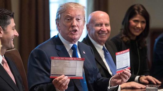 President Donald Trump shows samples of the proposed new tax form at the White House in Washington, DC, on November 2, 2017.
