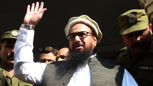Pakistan head of the Jamaat-ud-Dawa (JuD) organisation Hafiz Saeed waves to supporters as he leaves a court in Lahore on November 21, 2017.