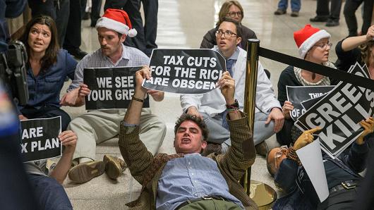 Protesters demonstrate near the full Senate budget committee markup of the tax reform legislation on Capital Hill November 28, 2017 in Washington, DC.