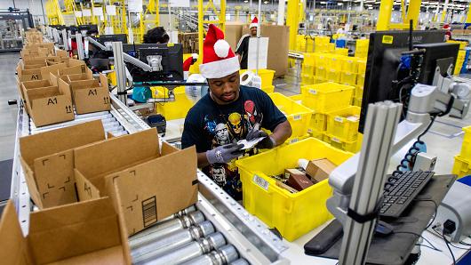 Amazon employees load boxes with orders at the company's fulfillment center ahead of Cyber Monday in Tracy, Calif.