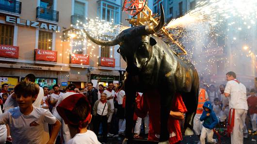 A man incarnating a 'Toro de Fuego' (bull of fire) chases people during the San Fermin Festival on July 8, 2017, in Pamplona, Spain.