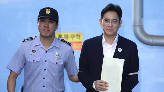 Jay Y. Lee, co-vice chairman of Samsung Electronics Co., right, is escorted by a prison officer as he leaves the Seoul Central District Court in Seoul, South Korea, on Friday, Aug. 25, 2017.