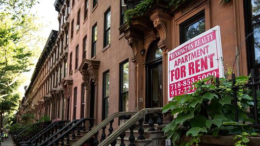 A sign advertises an apartment for rent along a row of brownstone townhouses on June 24, 2016 in the Brooklyn borough of New York City.