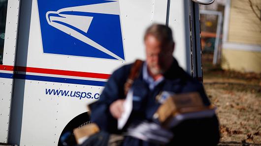 A United States Postal Service (USPS) letter carrier delivers mail in Shelbyville, Kentucky.