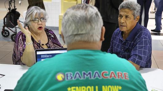 Isabel Diaz Tinoco (L) and Jose Luis Tinoco speak with Otto Hernandez, an insurance agent from Sunshine Life and Health Advisors, as they shop for insurance under the Affordable Care Act at a store setup in the Mall of Americas on November 1, 2017 in Miami, Florida.