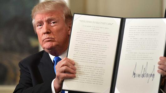 President Donald Trump holds up a signed proclamation after he delivered a statement on Jerusalem from the Diplomatic Reception Room of the White House in Washington, DC on December 6, 2017.