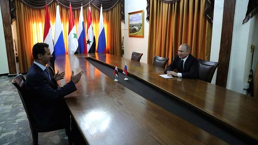 A handout picture released on the official Facebook page of the Syrian Presidency on December 11, 2017 shows Russian President Vladimir Putin (R) meeting with his Syrian counterpart Bashar al-Assad in the Russian air base in Hmeimim in the northwestern Syrian province of Latakia. Russian news agencies reported that Putin gave an order for partial withdrawal of Russian troops from Syria during his press conference on December 11.