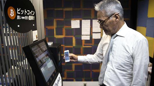 An employee uses a smartphone as he demonstrates how to purchase bitcoins from a bitcoin automated teller machine (ATM) at the Coin Trader bitcoin retail store in Tokyo, Japan, Aug. 30, 2017.