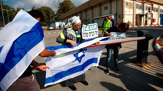 Israeli employees of Teva, the world's biggest manufacturer of generic drugs, protest outside the pharmaceutical company's plant in Kiryat Shmona, in northern Israel, on December 14, 2017.
