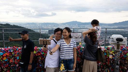 People take photographs at the observation deck on Mount Namsan in Seoul, South Korea on Aug. 11, 2017.
