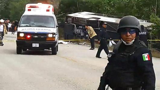 Video grab of Mexican police officers standing guard in the area where a bus driving tourists to Chacchoben archaeological zone overturned in the road in Mexico on December 19, 2017