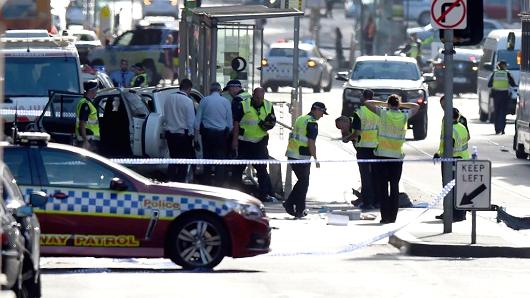Police and emergency personnel work at the scene of where a car ran over pedestrians in Flinders Street in Melbourne on December 21, 2017. The car ploughed into a crowd in Australia's second-largest city on December 21, injuring at least a dozen people, some of them seriously, officials said.