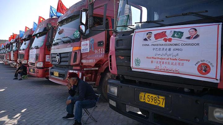 A Chinese worker sits near trucks carrying goods during the opening of a trade project in Gwadar Port, Pakistan, on November 13, 2016.