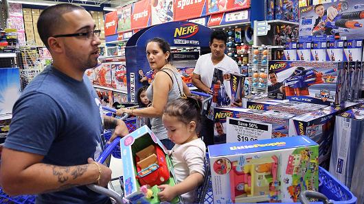 Johnathan Beauchamp, left, and daughter Alaya, 1, squeeze by fellow shoppers Diana Barrios, center, and husband Pablo Barrios, right, to shop at the 'Toys R Us' in Doral, Fla.