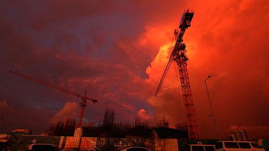 Cranes stand during the sunset at a construction site at the hotel complex construct by Chinese company on October 15, 2015 in Colombo, Sri Lanka.