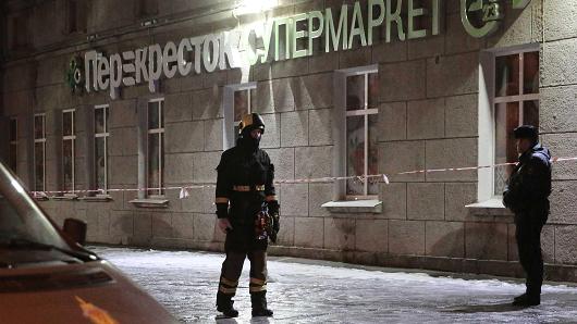 An Emergency Ministry member and a policeman are seen outside a supermarket after an explosion in St Petersburg, Russia, December 27, 2017.