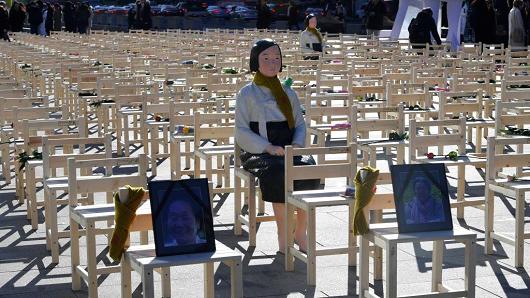 A statue of a 'comfort woman' is displayed in an installation of empty chairs set up in central Seoul to commemorate the death of eight former sex slaves.