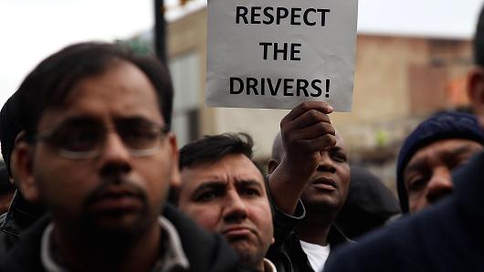 Uber drivers protest the company's recent fare cuts and go on strike in front of the car service's New York offices on February 1, 2016.