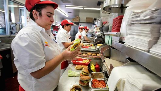An employee prepares burgers for lunch customers at In-N-Out in San Marcos, California.