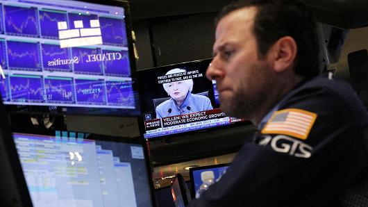 A trader works on the floor of the New York Stock Exchange as a television screen displays coverage of U.S. Federal Reserve Chairman Janet Yellen shortly after the announcement that the U.S. Federal Reserve will hike interest rates in New York, December 14, 2016.