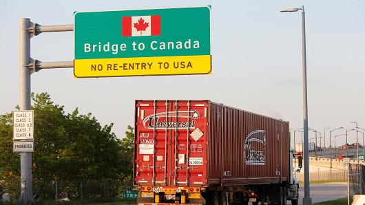 A semi truck headed for Windsor, Ontario, drives onto the Ambassador bridge in Detroit, Michigan.