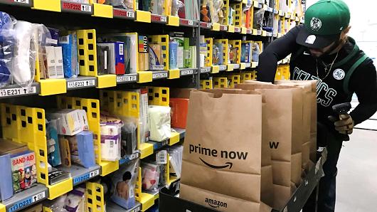 An employee collects items ordered by Amazon.com customers through the company's two-hour delivery service Prime Now in a warehouse in San Francisco, December 20, 2017.