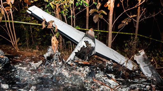 The tail of the burned fuselage of a small plane that crashed, rests near trees in Guanacaste, Corozalito, Costa Rica on December 31, 2017.
