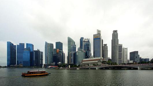 A tourist boat travels past the city skyline in Singapore, on July 12, 2017.