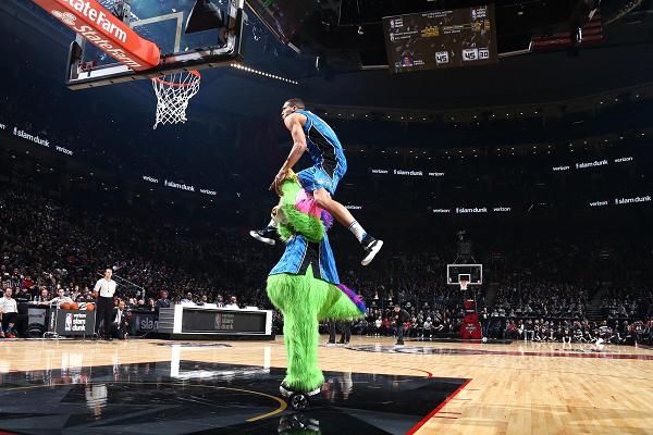 Aaron Gordon of the Orlando Magic dunks over Stuff the Magic Dragon, the mascot of the Orlando Magic, during the Verizon Slam Dunk Contest in 2016