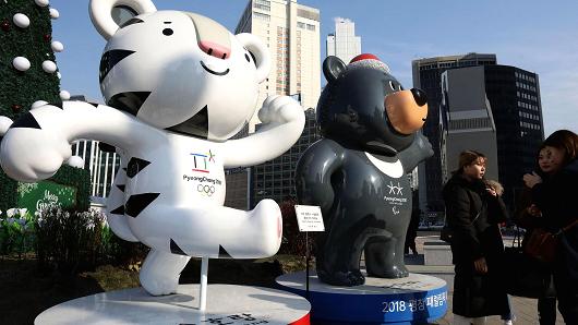 People walk in front of mascots of the 2018 PyeongChang Winter Olympic and Paralympic Games Soohorang (L) and Bandabi (R) on January 5, 2018 in Seoul, South Korea.