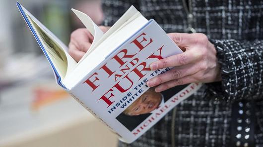 A man holds a copy of the book 'Fire and Fury: Inside the Trump White House' by Michael Wolff after buying it at a bookstore in Washington, DC on January 5, 2018.