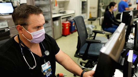 Emergency room nurse Richard Horner wears a mask as he deals with flu patients at Palomar Medical Center in Escondido, California, January 18, 2018.