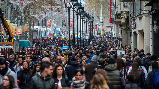 People walk along a crowed shopping street on the first day of the winter sales on January 7, 2015 in Barcelona, Spain
