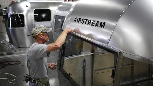 A factory worker installs rivets on the rear window of an Airstream RV travel trailer at the company's assembly plant in Jackson Center, Ohio.
