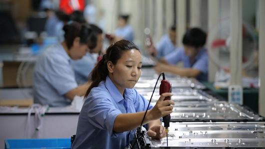 Workers assemble televisions on the production line of Tianle Group Co., Ltd on July 3, 2012 in Shengzhou of Zhejiang Province, China.