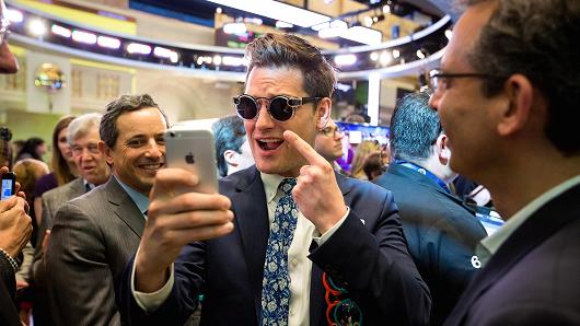 Matthew Kobach, manager of digital and social media at the New York Stock Exchange (NYSE), center, takes a selfie photograph wearing a pair of Snapchat Spectacles by Snap Inc. on the floor of the New York Stock Exchange (NYSE) during the company's initial public offering (IPO) in New York.