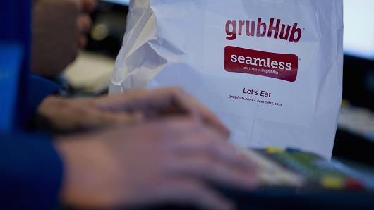 A trader works next to a Grubhub Inc. paper bag on the floor of the New York Stock Exchange (NYSE) in New York.
