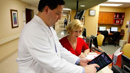 A doctor demonstrates an app on an iPad to review medical tests of one of his patients at Northwest Medical Center in Margate, Florida.