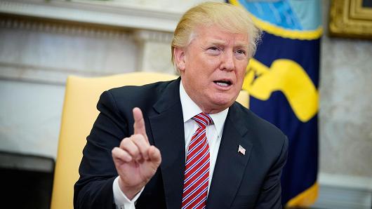 President Donald Trump responds to a reporter's question on domestic violence following a working session regarding opportunity zones following the recently signed tax bill in the Oval Office of the White House on February 14, 20218 in Washington, DC.