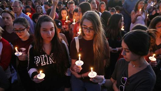 People attend a candlelit memorial service for the victims of the shooting at Marjory Stoneman Douglas High School
