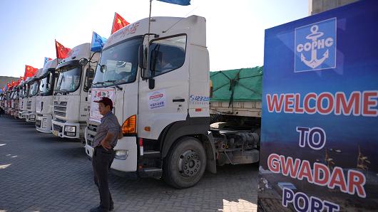 A Chinese worker stands near trucks during the opening of a trade project at Pakistan's Gwadar port on November 13, 2016.