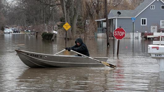 A resident uses a rowboat to navigate a flooded neighborhood on February 22, 2018 in Lake Station, Indiana.