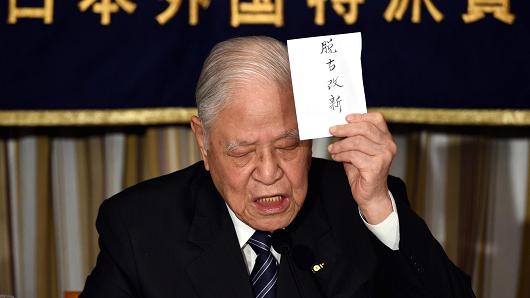Former Taiwanese president Lee Teng-hui displays a sign reading 'departure from the old, bracing for the new' during a luncheon in which he spoke about the 'establishment of Taiwan's Autonomy' at the Foreign Correspondents' Club in Tokyo, Japan, on July 23, 2015.