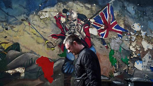 A man walks past a mural marking unionist territory on May 4, 2016 in Londonderry, Northern Ireland.