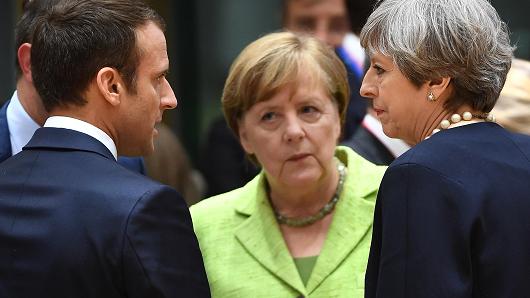 (From L) French President Emmanuel Macron, German Chancellor Angela Merkel and British Prime Minister Theresa May talk as they attend an European Union leaders summit, on June 22, 2017, at the European Council in Brussels.